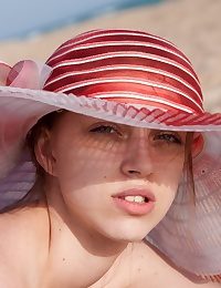 Arina wears a wide-brimmed hat dimension out nude sunbathing