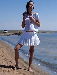 X brunette teen posing bottomless on the beach