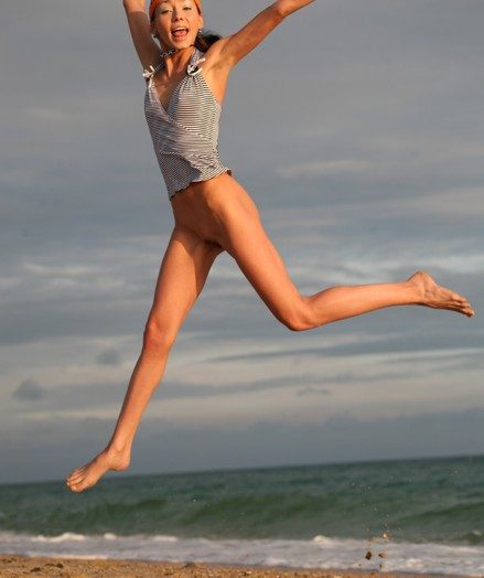 Very skinny and natty teen jumping and flying naked on the shore